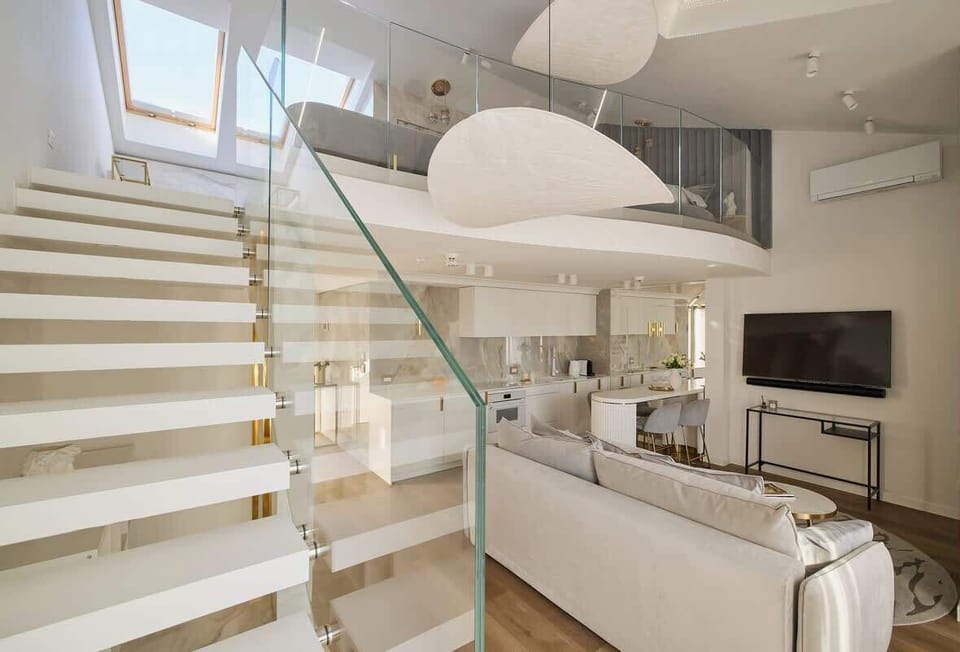 Przestronny, klimatyzowany i jasny salon urządzony został w eleganckim, minimalistycznym stylu. Wygodna sofa z funkcją spania, designerskie oświetlenie oraz starannie dobrane dodatki tworzą atmosferę sprzyjającą relaksowi i wypoczynkowi. 