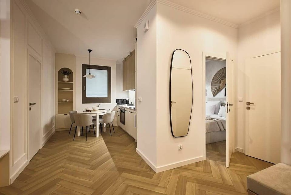 Przytulny salon z rozkładaną sofą to idealne miejsce do wspólnego wypoczynku – wygodny narożnik, designerski stolik i duży telewizor tworzą domowy klimat. Jasne ściany, miękkie tekstylia i eleganckie dodatki sprzyjają relaksowi po dniu pełnym wrażeń.