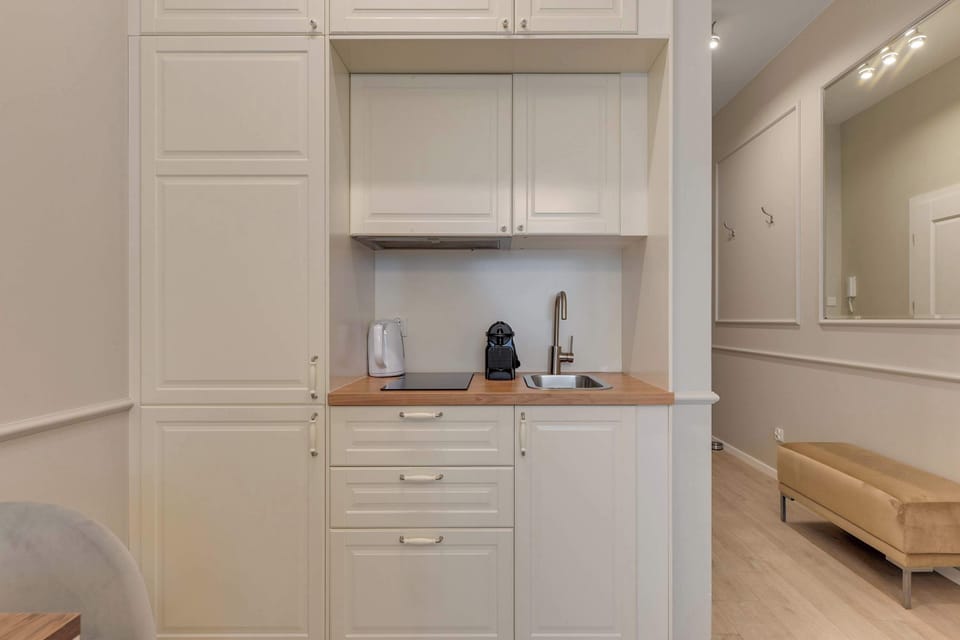 Apartament oferuje aneks kuchenny z niezbędnym wyposażeniem, stół z krzesłami oraz zestaw powitalny z kawą, herbatą i przyprawami.
