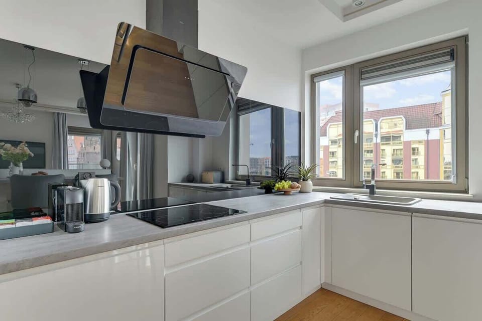 Nowoczesny aneks kuchenny został zaprojektowany z myślą o wygodzie i pełnej funkcjonalności. Do dyspozycji gości są: mikrofalówka, piekarnik, płyta indukcyjna, zmywarka, lodówka, czajnik oraz ekspres do kawy.