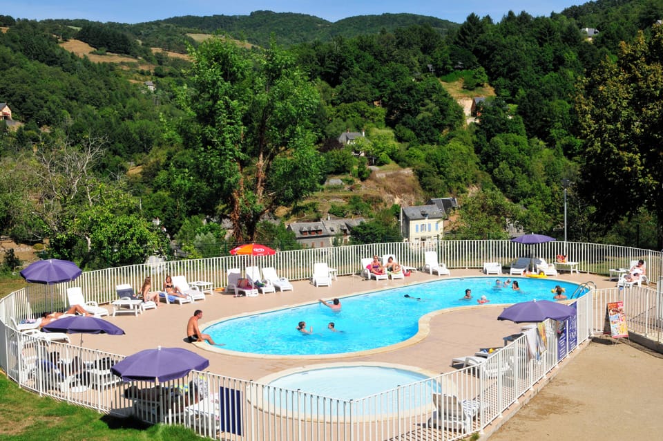 The outdoor heated pool and sun terrace, open from mid-May to mid-September with the Aveyron hillsides as a backdrop.