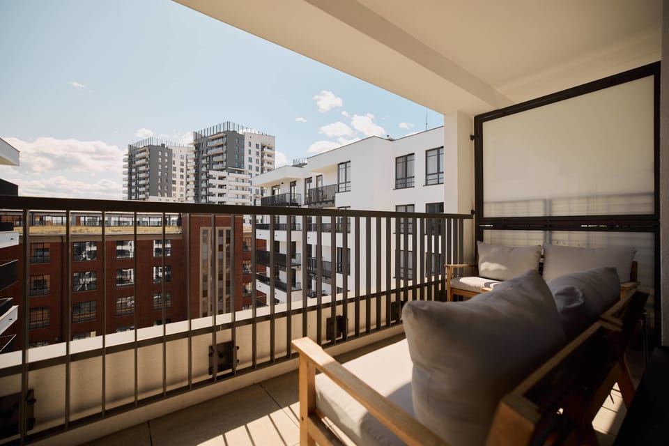 Apartament posiada również balkon z widokiem na wewnętrzne patio - idealne miejsce na poranną kawę lub chwilę odpoczynku po dniu spędzonym w mieście.