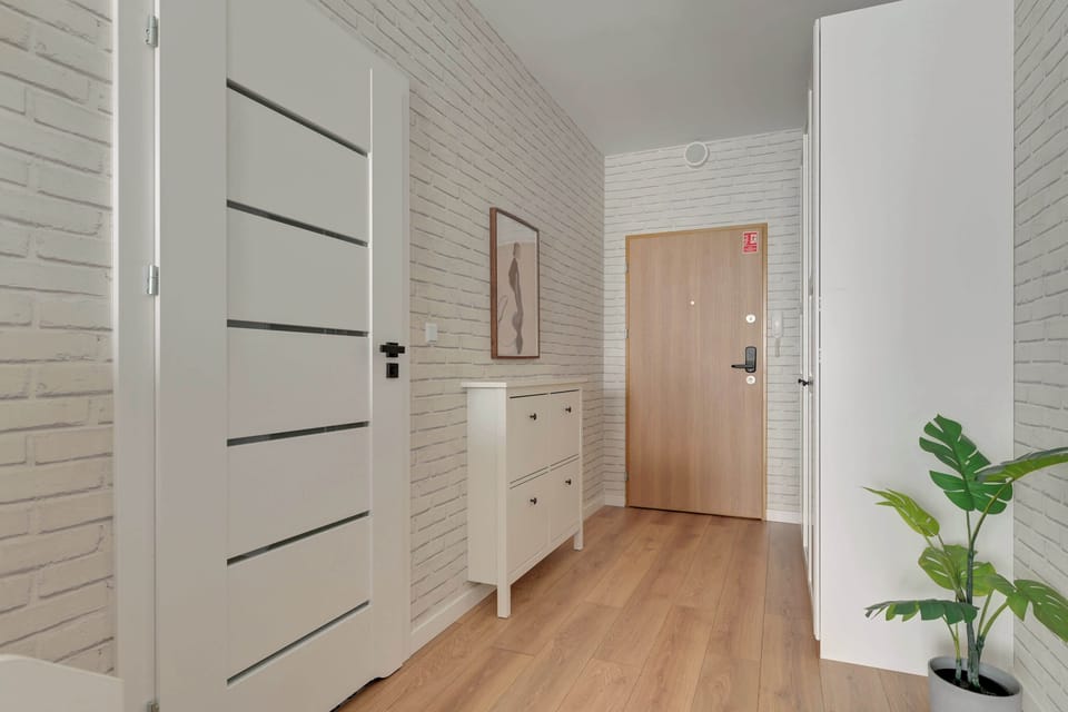 Główną część apartamentu stanowi wygodne łóżko małżeńskie z miękkim, tapicerowanym zagłówkiem oraz kompletem pościeli i ręczników. Naprzeciwko łóżka znajduje się telewizor z funkcją Smart TV oraz dostępem do kanałów satelitarnych.