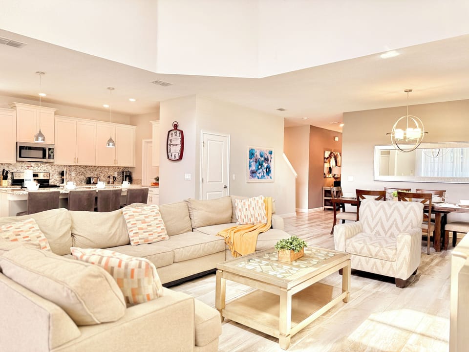 Open-concept great room connecting the living area, kitchen, and dining suite.