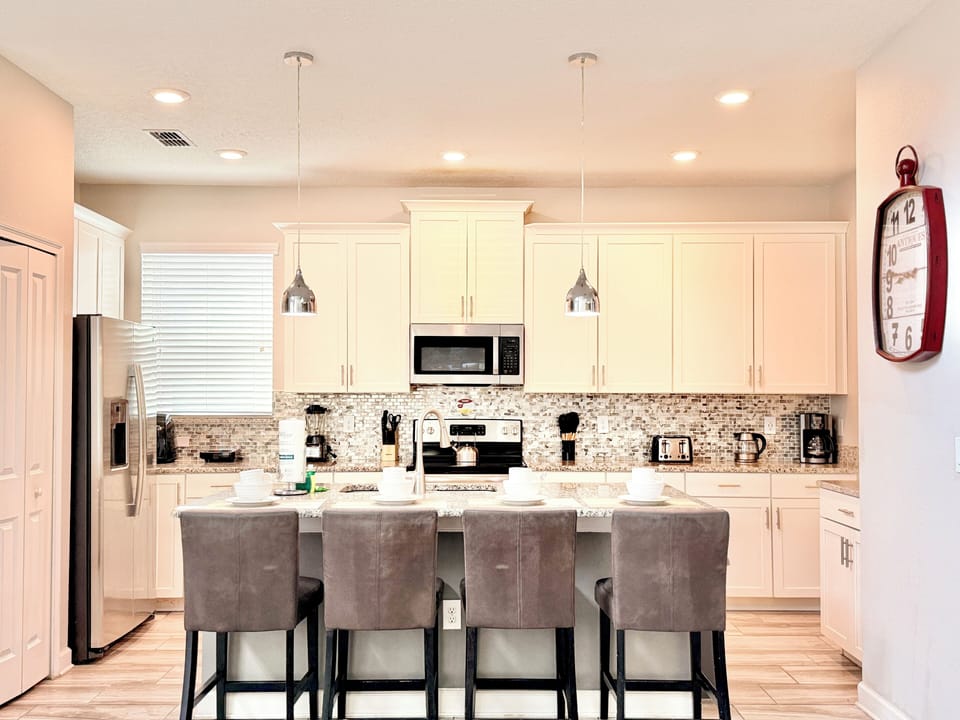 Modern fully equipped kitchen featuring white cabinetry and a breakfast island.