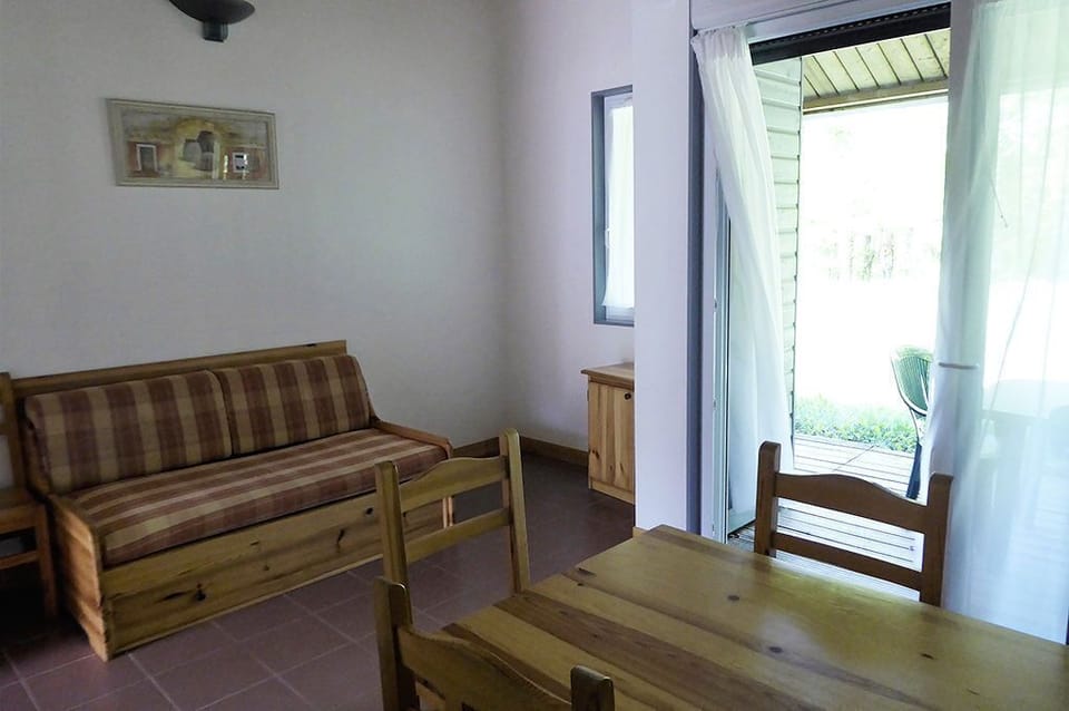 Sofa bed in the living room, with the terrace door open to the garden.