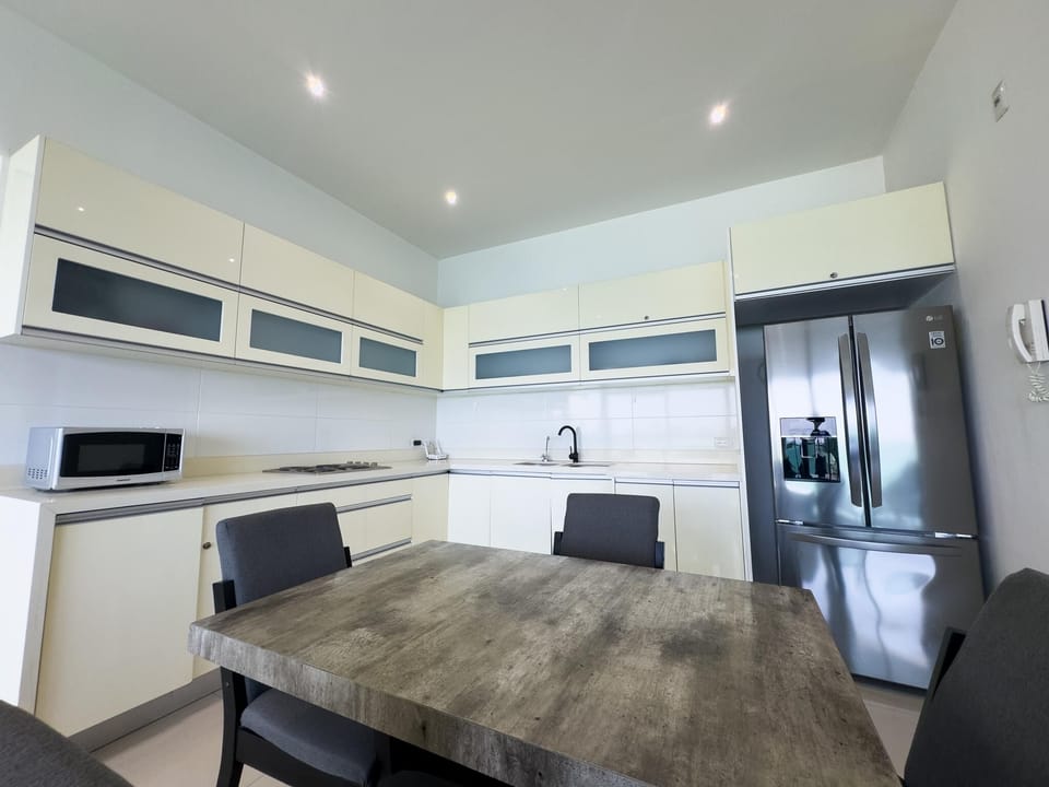 Matte black faucet contrasts with cream cabinetry and frosted glass panel doors in the kitchen.
