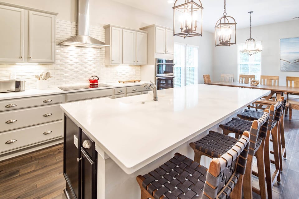 The kitchen is the star of the show with a central island, tiled backsplash & quartz counters.