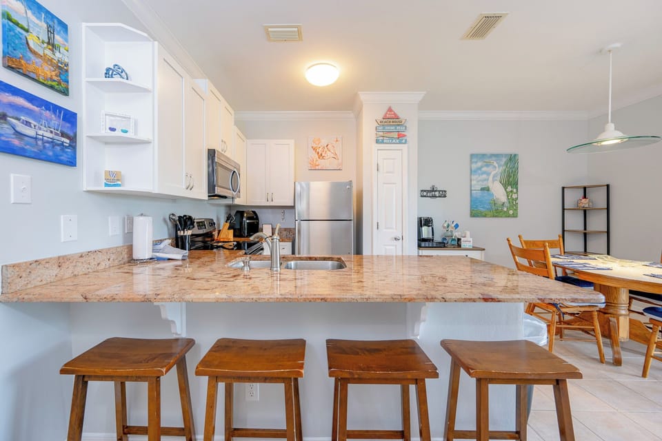 Granite countertop invites you to gather around the kitchen bar and enjoy casual bites during your stay