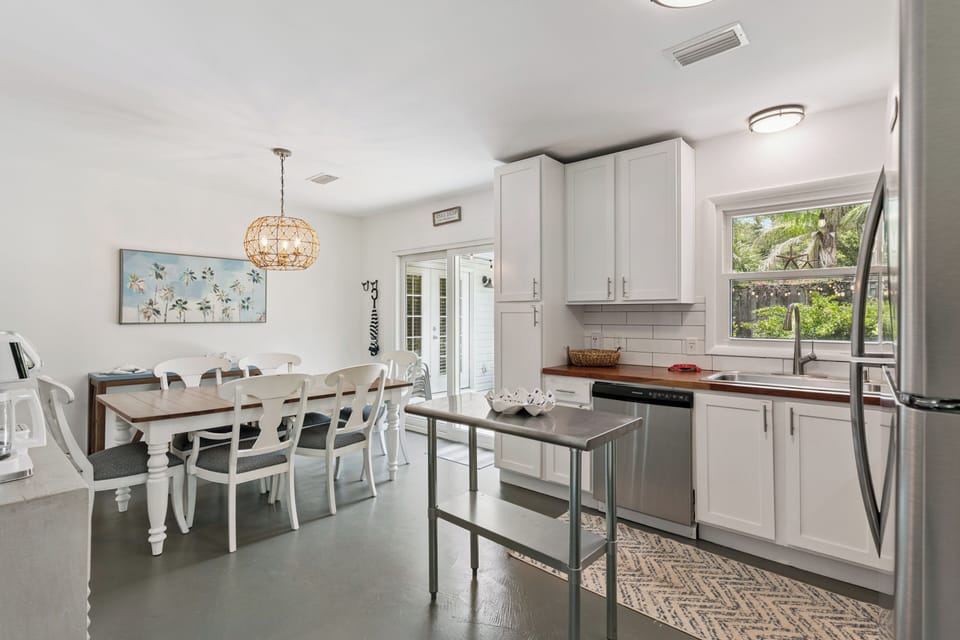 Gather around the large farmhouse table in your bright, fully equipped kitchen-dining space. With stainless appliances, abundant storage, and natural light streaming in, you'll love preparing and sharing meals together here.