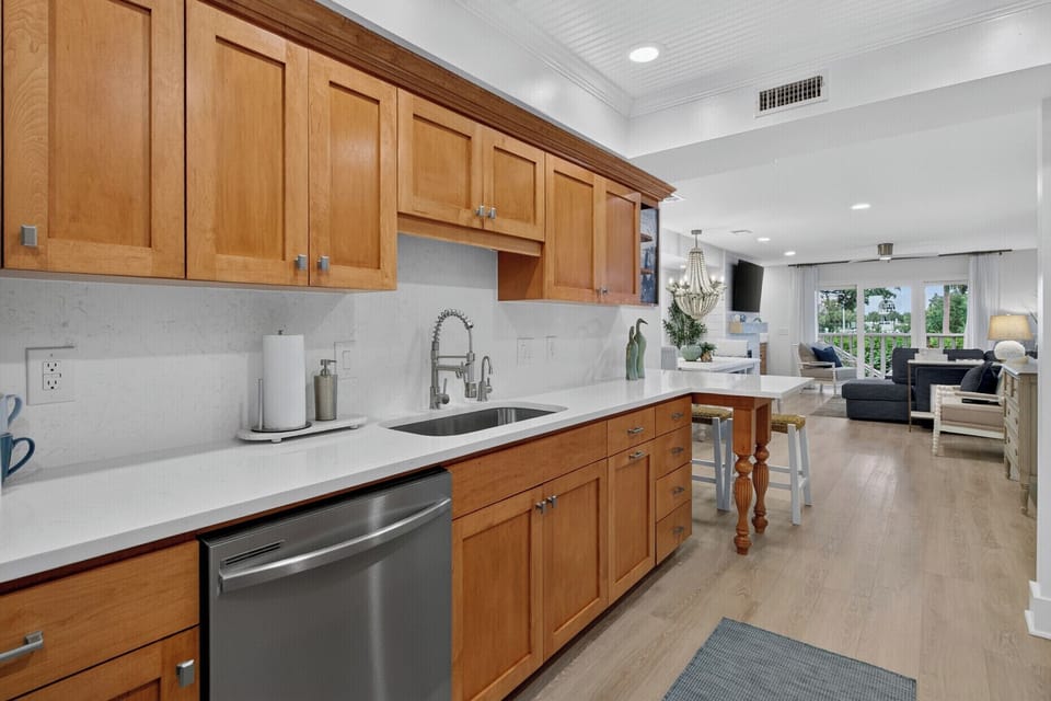 Step into a bright, open kitchen where warm wood cabinetry meets clean white countertops. Everything you need flows effortlessly into your living area—perfect for cooking, relaxing, and making yourself at home.