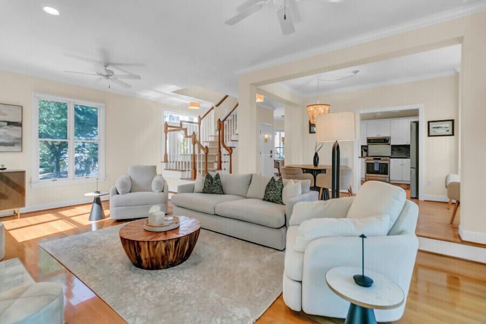 Sink into plush seating in this bright, airy living room where warm wood floors and natural light create your perfect retreat for relaxation and conversation.