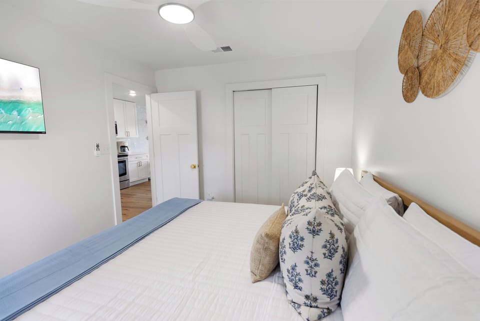 Sink into crisp white linens and let coastal touches like woven wall art and ocean-hued accents calm your mind. The adjoining kitchen means morning coffee is steps away.