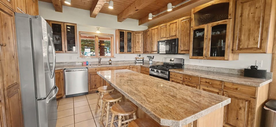 Rustic gourmet kitchen with granite island and bar seating