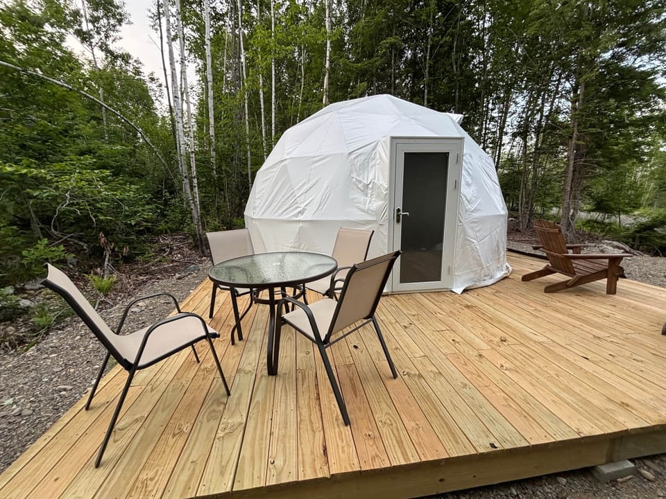 Dome 1 Entrance with dining table and Adirondack chairs.