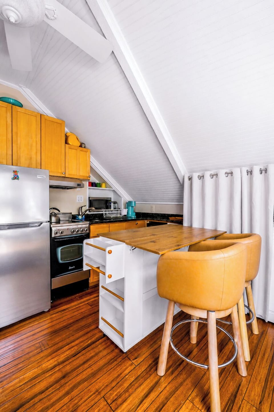 Cozy loft kitchen with island seating and stainless appliances