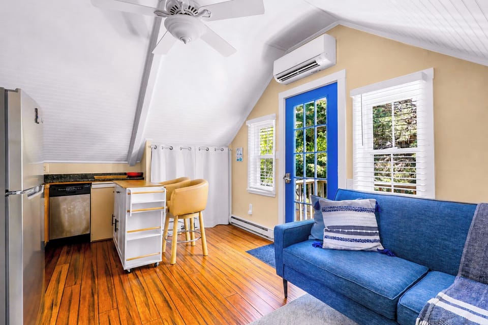 Bright loft-style studio with kitchenette, bar seating, and cheerful blue accents