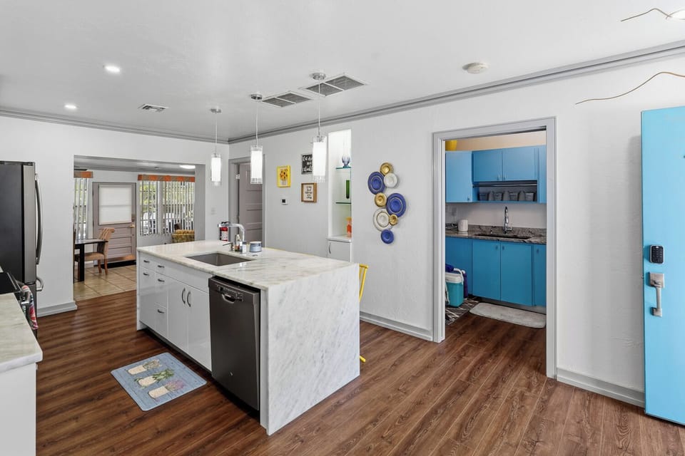 Bright modern kitchen with large island, stylish finishes, and bold blue accents
