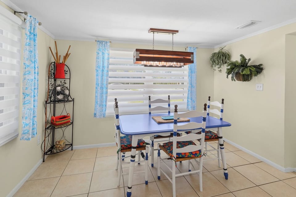 Bright coastal dining nook with colorful seating and sunny window views