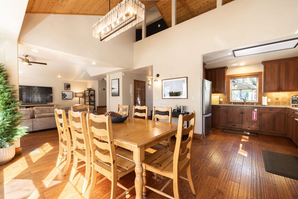 Gather around the large wooden dining table under vaulted ceilings—perfect for family meals and reconnecting after a day on the mountain.