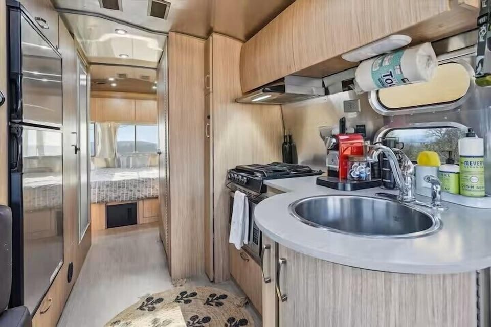 Cozy RV interior with kitchenette, coffee station, and bright sleeping nook
