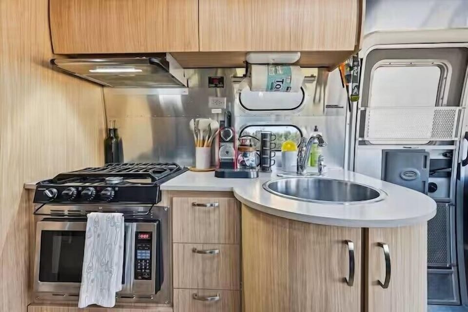 Compact modern kitchen with gas range, coffee station, and stylish finishes