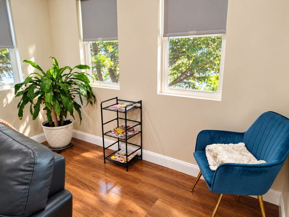Unwind in this cozy reading nook with a comfortable chair, natural light, and magazines—perfect for a quiet moment during your stay.