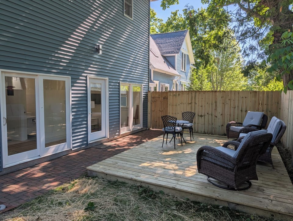 EXTERIOR: The cute fenced-in backyard with plenty of seating. Fun and relaxing times found here!