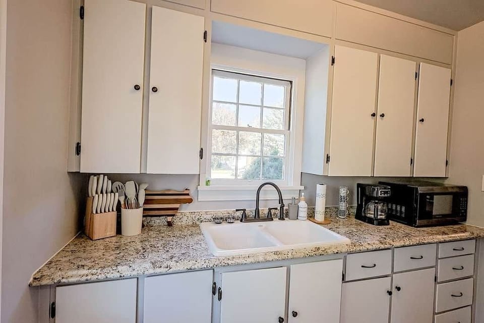 Well‑stocked kitchen counter with sink, coffee maker, microwave, and cooking essentials