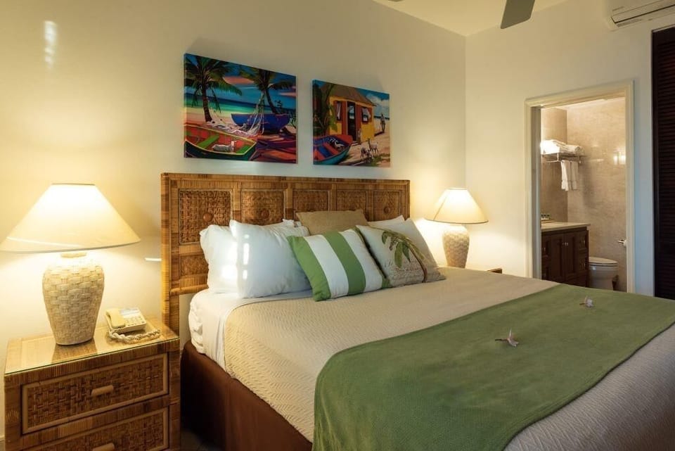 Unwind in a serene king bedroom with warm island touches.