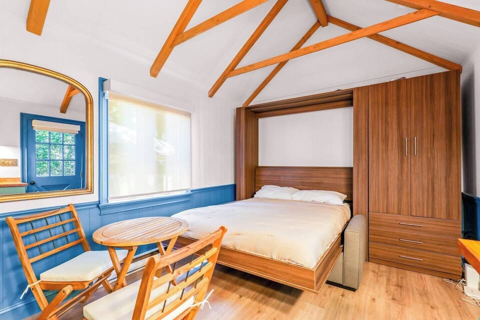 Unwind in a cozy Murphy bed beneath soaring vaulted ceilings and exposed wood beam