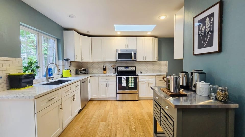 Bright, fully equipped kitchen with ample counter space, skylights natural light, and modern appliances