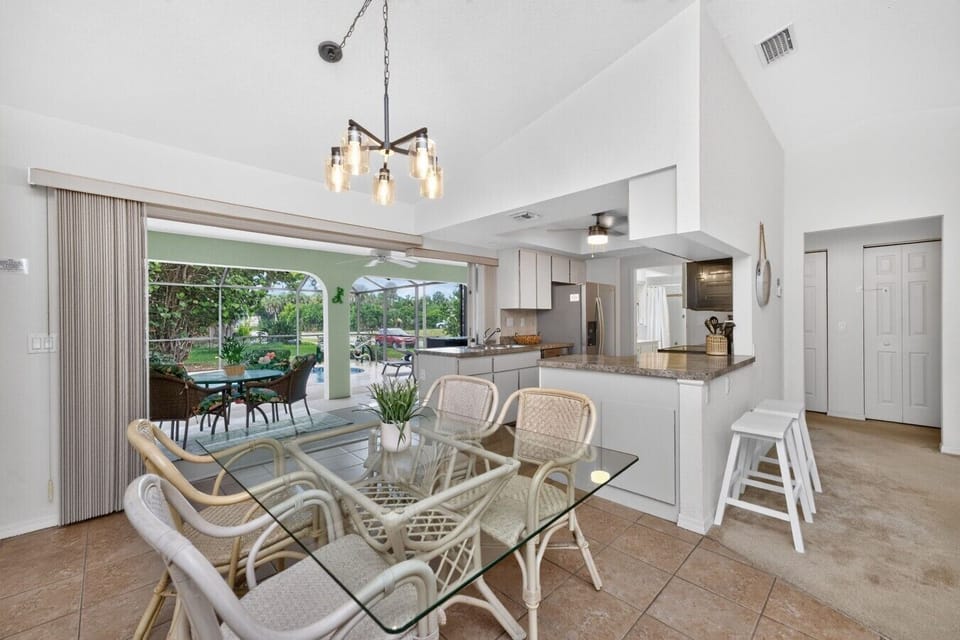 Enjoy meals together in the bright dining area with seating for six, a breakfast bar, and a fully equipped kitchen, with sliding doors opening to the screened lanai and private pool for true indoor-outdoor Florida living.