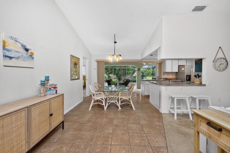 Open dining area with seating for six, breakfast bar, and a fully equipped kitchen—perfect for family meals, game nights, and gathering after a day exploring Port Charlotte.
