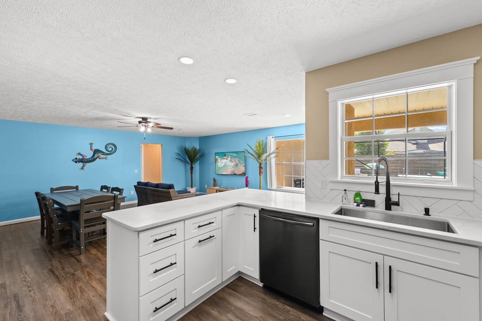 Bright, airy, and built for gathering. This expansive countertop offers plenty of room for meal prep or serving buffet-style, all while looking out over the main living space and coastal decor.