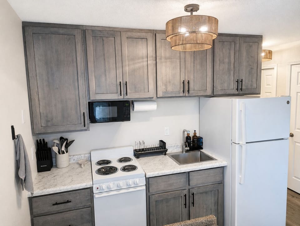 Modern compact kitchen with stylish gray cabinets and full-size appliances