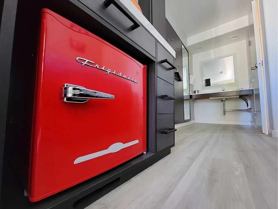 Enjoy quick snacks with stylish fridge and modern kitchenette.