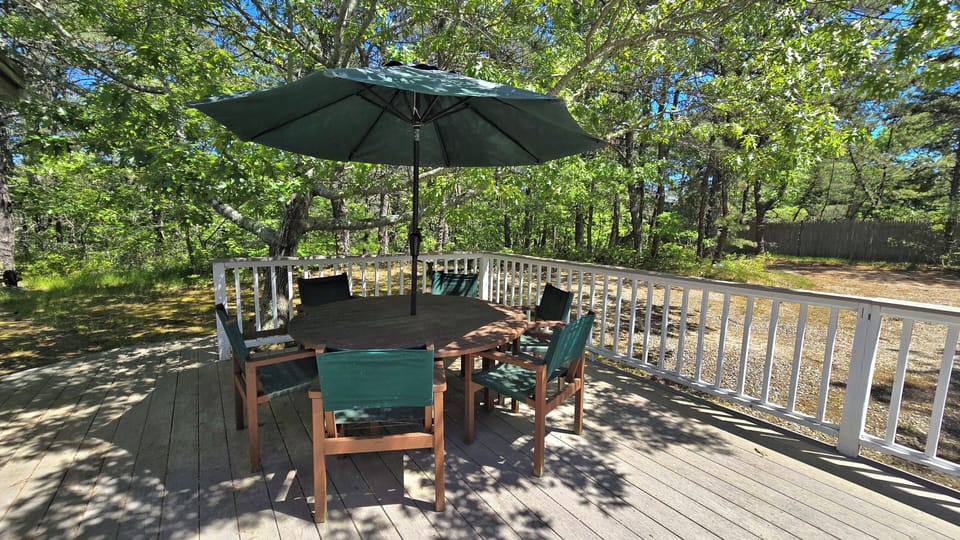 Front deck with lounge chairs at one end and dining table at the other end