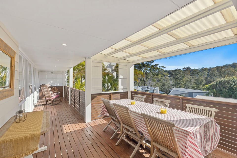 Spacious covered deck with outdoor dining and peaceful treetop views