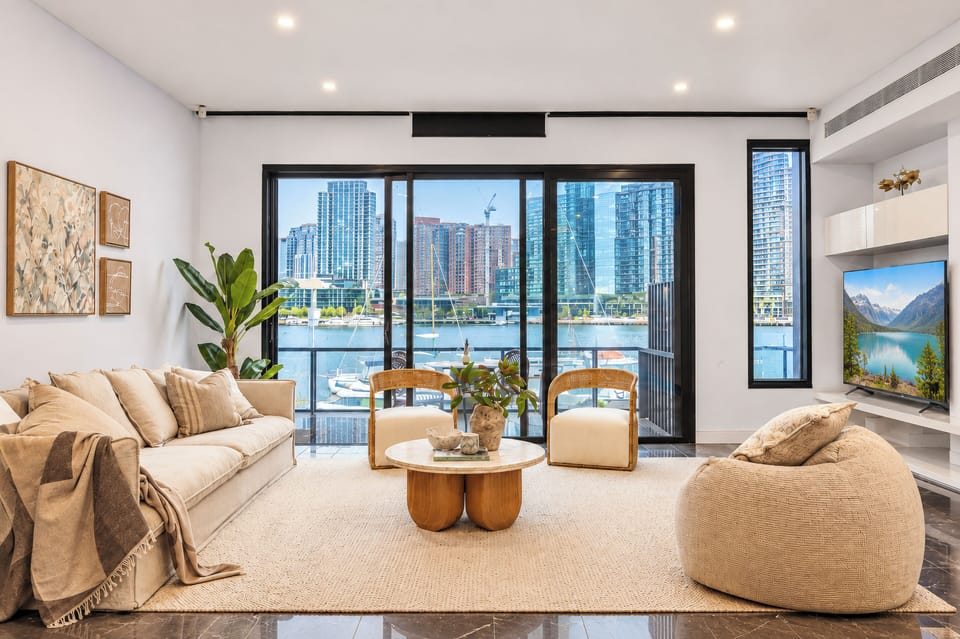 Bright waterfront lounge with balcony and stunning city skyline views