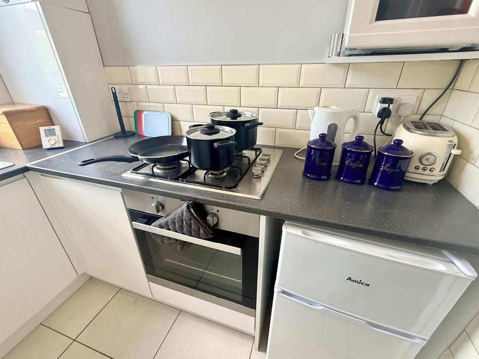 Compact yet fully equipped kitchen with everything you need to prepare meals, including cookware, crockery, utensils, and essential appliances for short or extended stays.