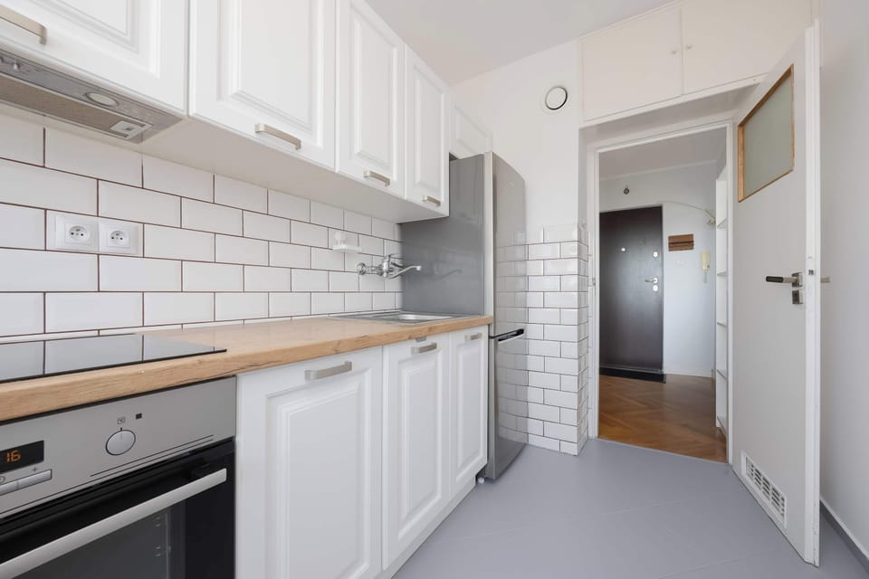 A view of the kitchen leading toward the apartment entrance. The practical design offers convenience and easy access to every room.