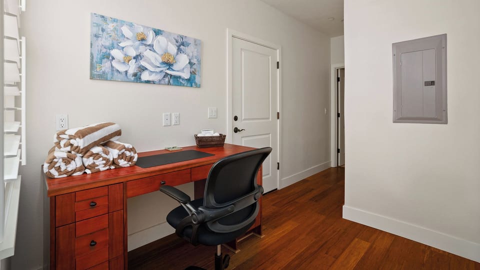 Set up your workspace at the warm wood desk, where fresh towels and bright artwork create a welcoming corner for catching up on emails or planning your day.