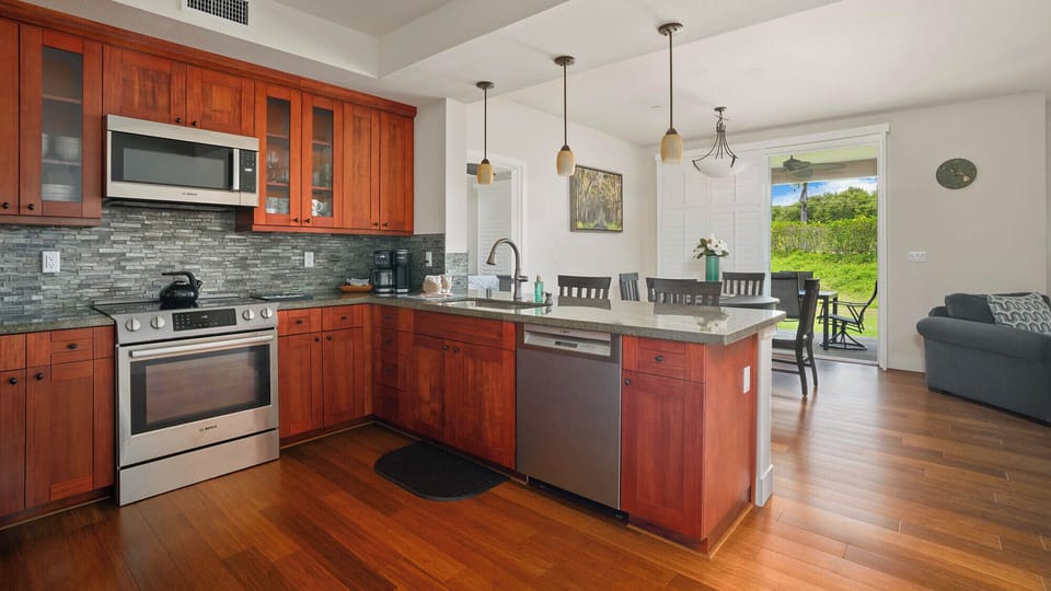 Your fully equipped kitchen opens to a sun-drenched dining area with lush garden views, perfect for brewing morning coffee or gathering over meals with loved ones.