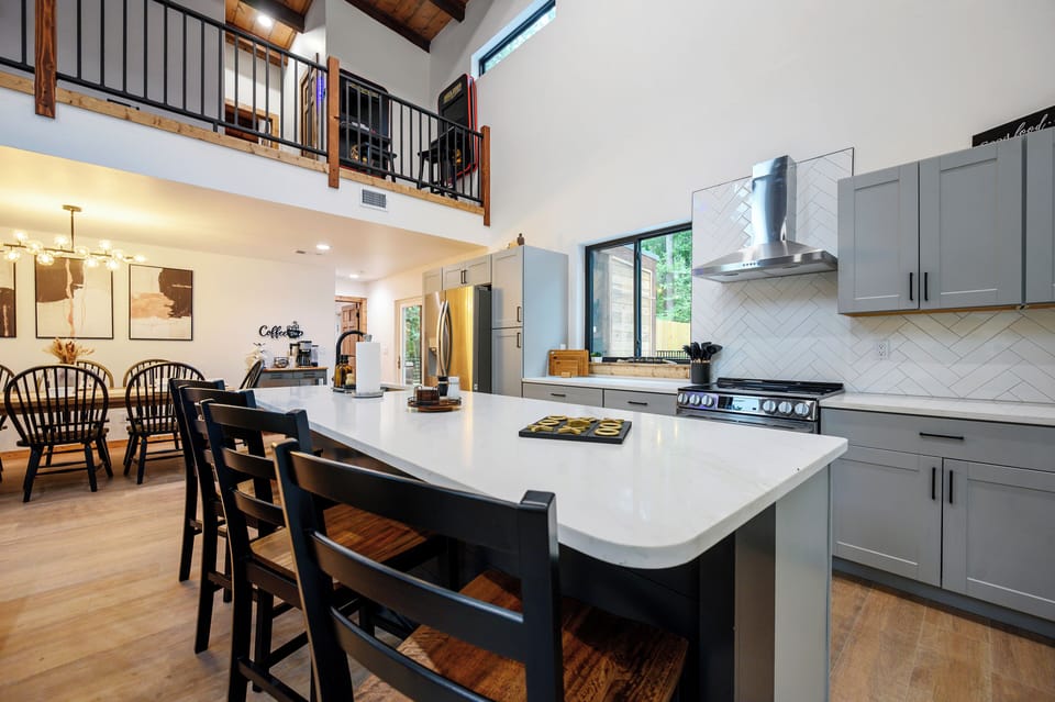 Spacious modern kitchen with vaulted ceilings, loft views, and island seating