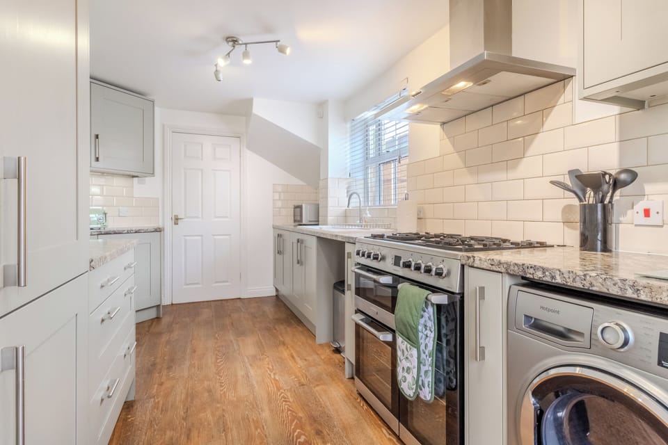 Bright modern kitchen with stylish finishes, full-size range, and washer