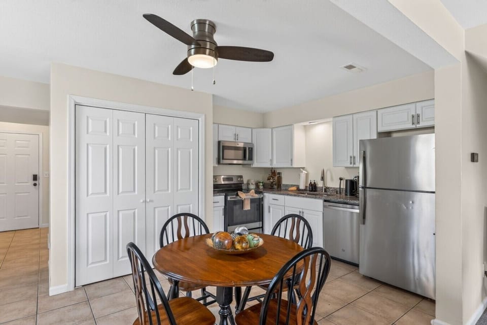 Bright eat-in kitchen with stainless appliances and a round dining table for four.