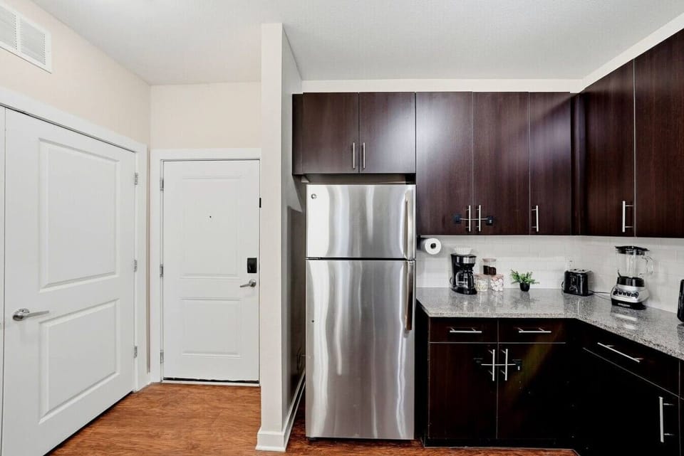 Full-size stainless steel fridge tucked in w/ plenty of counter space
