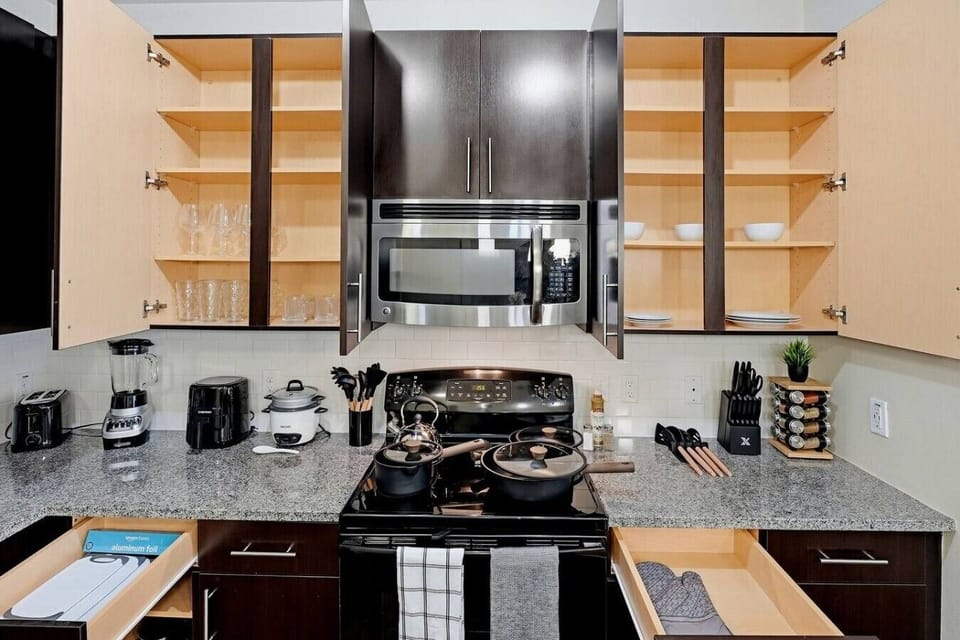 Well-equipped kitchen w/ open shelving, microwave & granite counters