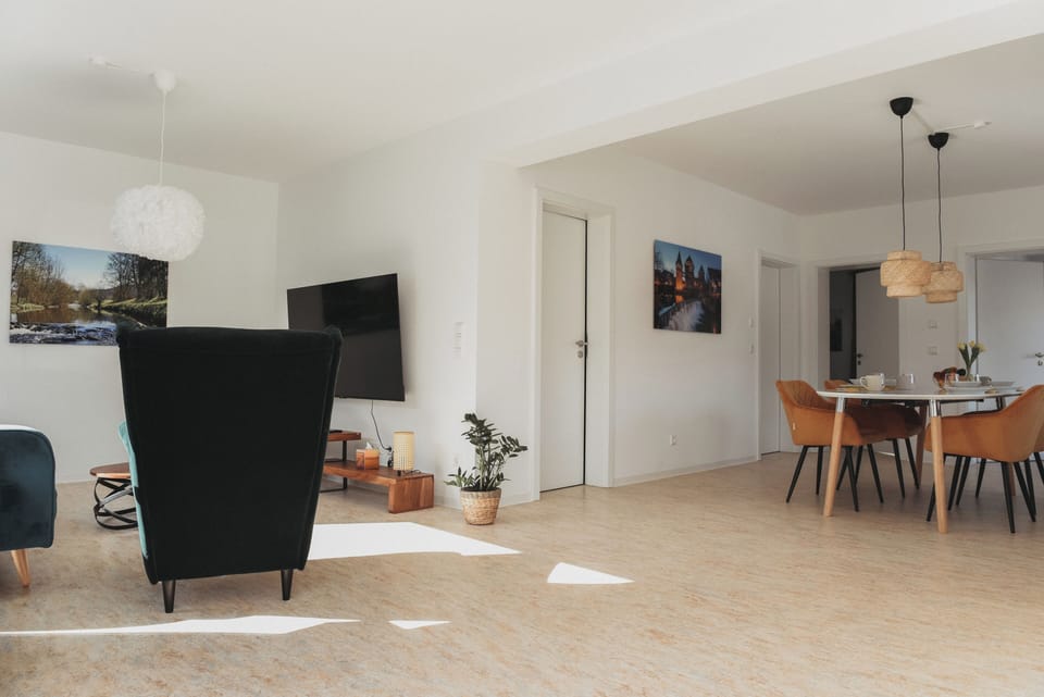 Sunny open-plan lounge & dining with stylish decor and wall-mounted TV